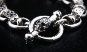 Pulsera de plata con cierre de calavera y hueso, un detalle de cadena seguridad pulsera que evoca misterio y estilo.