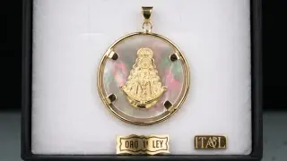 Colgante de oro con la Virgen del Rocío sobre nácar iridiscente. Un detalle de fe y elegancia.