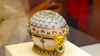 Un huevo de Fabergé adornado con oro, gemas y esmalte, con un león dorado en el lateral.