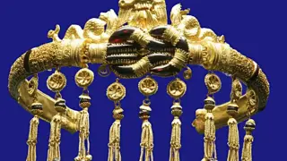 Un tocado dorado con intrincados detalles, colgantes y gemas oscuras. Una de las joyas famosas que evoca la riqueza de civilizaciones antiguas.