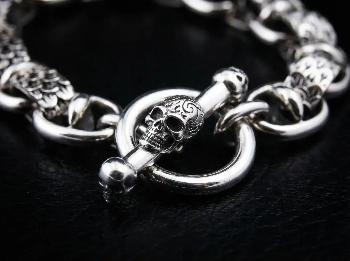 Pulsera de plata con cierre de calavera y hueso, un detalle de cadena seguridad pulsera que evoca misterio y estilo.