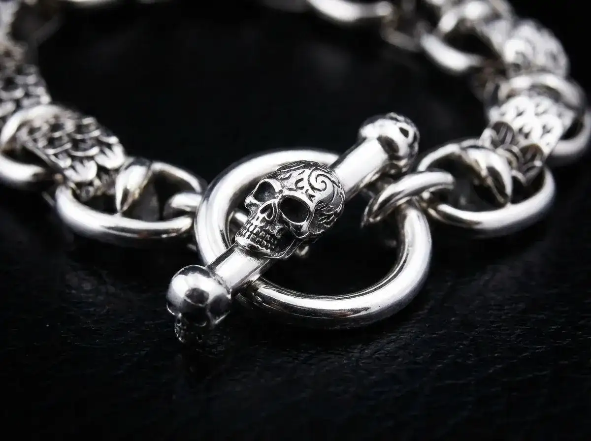Pulsera de plata con cierre de calavera y hueso, un detalle de cadena seguridad pulsera que evoca misterio y estilo.
