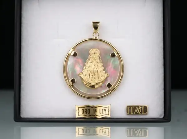 Colgante de oro con la Virgen del Rocío sobre nácar iridiscente. Un detalle de fe y elegancia.