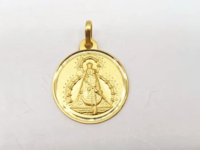 Medalla de oro con imagen de la Virgen, detalle de la **medalla oro virgen grande** con su halo y manto.
